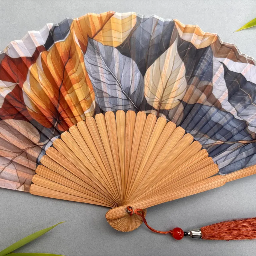 Handheld fan with leaf pattern on a gray background