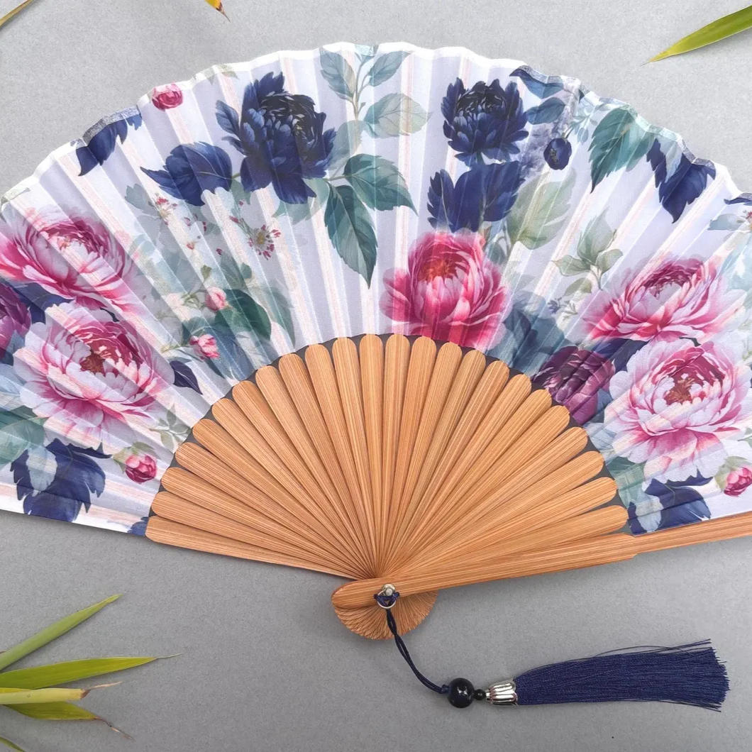 Floral-patterned hand fan on a gray background