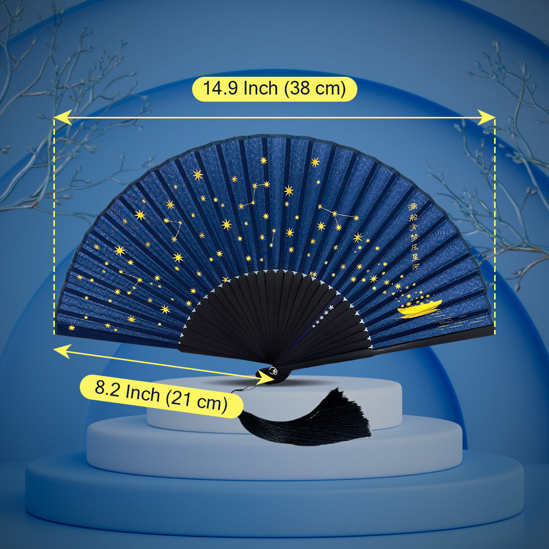 Navy blue silk folding hand fan with golden star and constellation design, displayed on a podium with size dimensions labeled as 38 cm wide and 21 cm tall