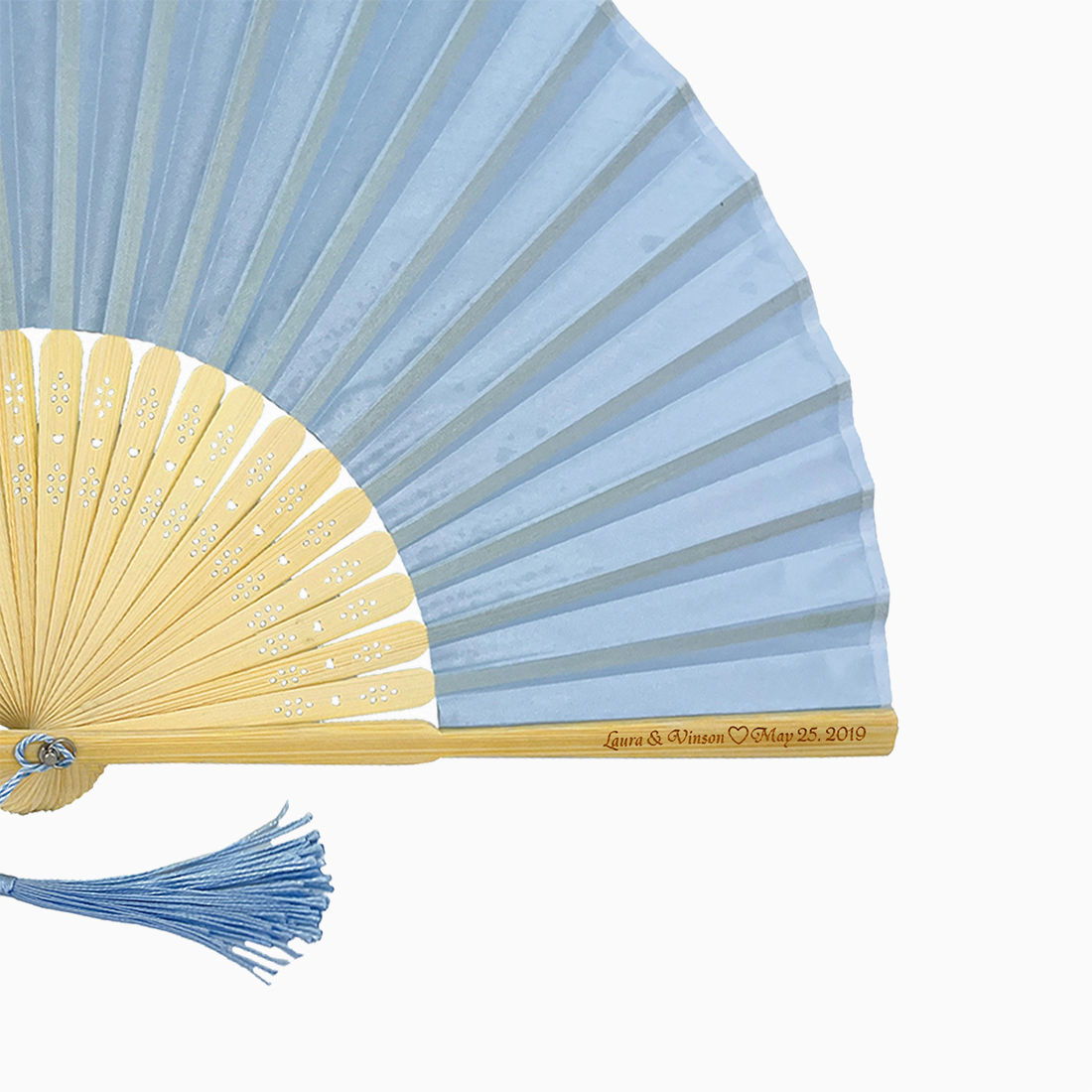 A folding fan with baby blue and beige hues features a stylish tassel. Its engraved text on the wooden rib, radiating elegance and charm.