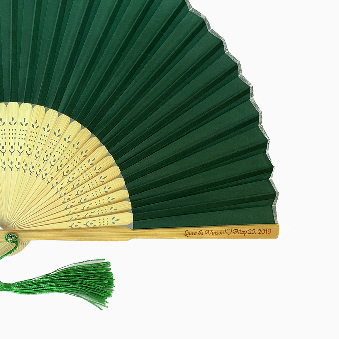 A folding fan with Emarald Green and beige hues features a stylish tassel. Its engraved text on the wooden rib, radiating elegance and charm.
