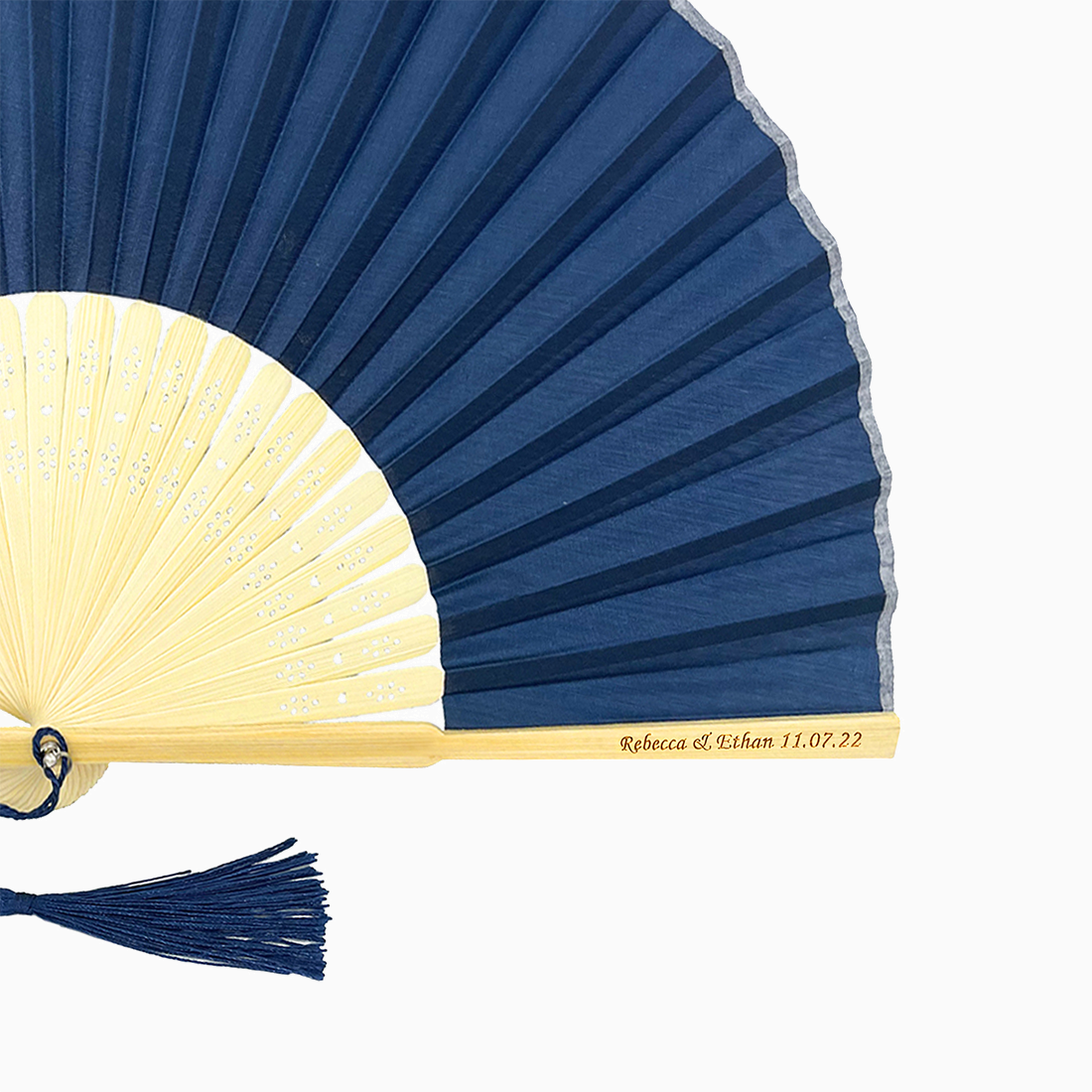 A folding fan with Navy Blue and beige hues features a stylish tassel. Its engraved text on the wooden rib, radiating elegance and charm.