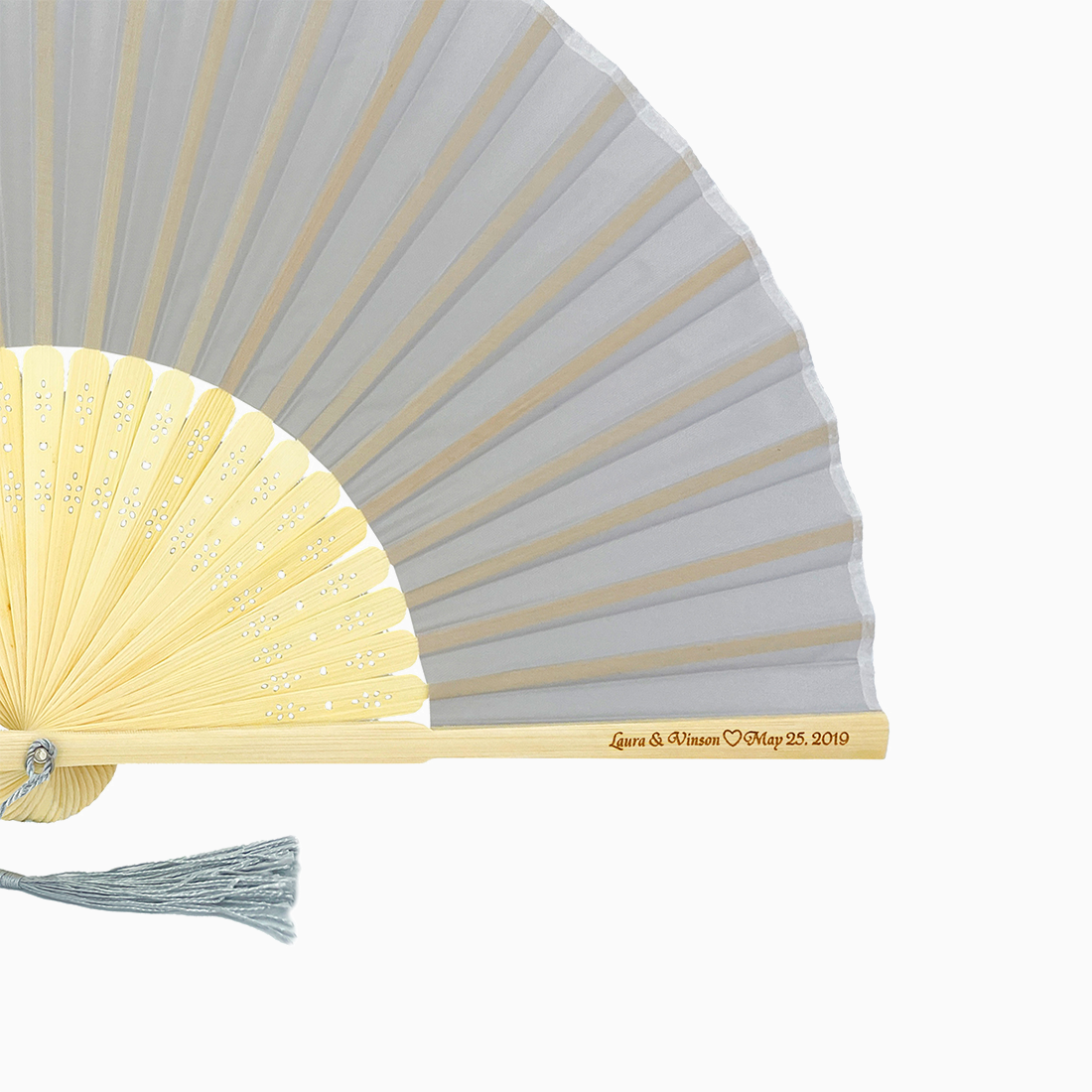 A folding fan with Silver Gray and beige hues features a stylish tassel. Its engraved text on the wooden rib, radiating elegance and charm.