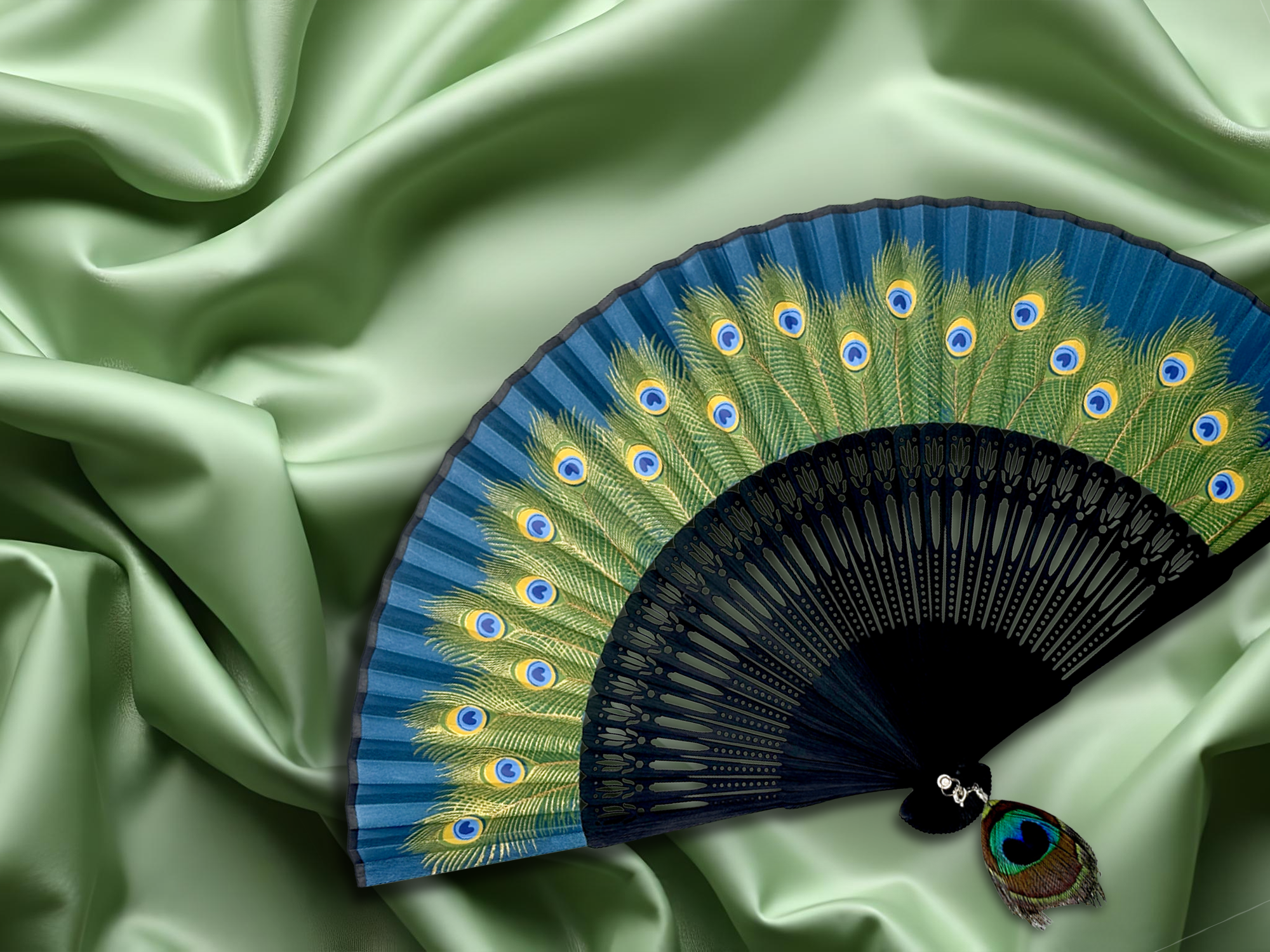 Hand fan adorned with vibrant peacock feathers, resting on a rich green fabric background.