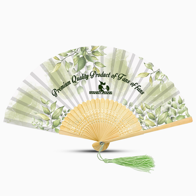 A green hand fan featuring a floral design and a green tassel, elegantly displayed against a neutral background.
