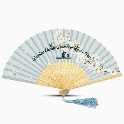 A light blue hand fan featuring a floral design and a light blue tassel, elegantly displayed against a neutral background.
