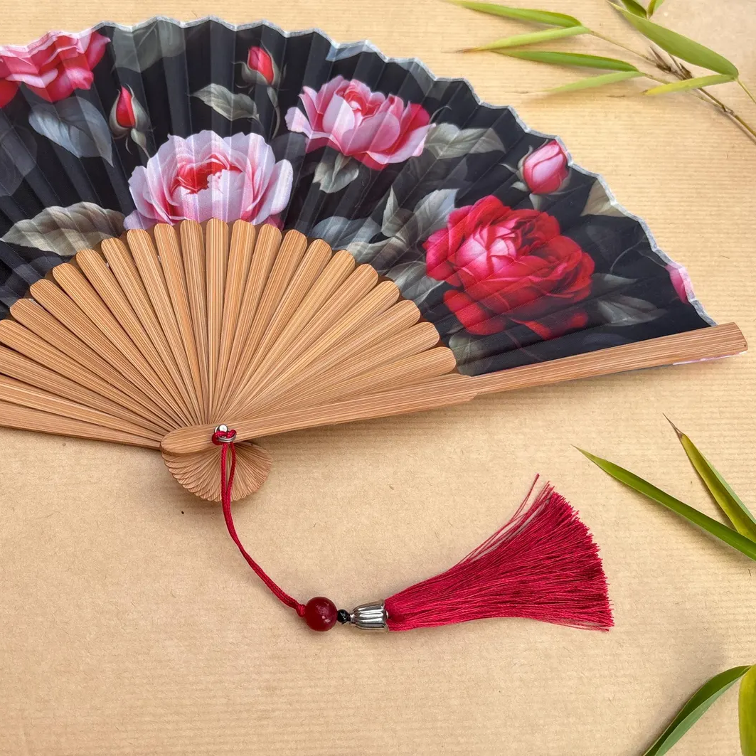 Handheld fan with floral design on a wooden surface