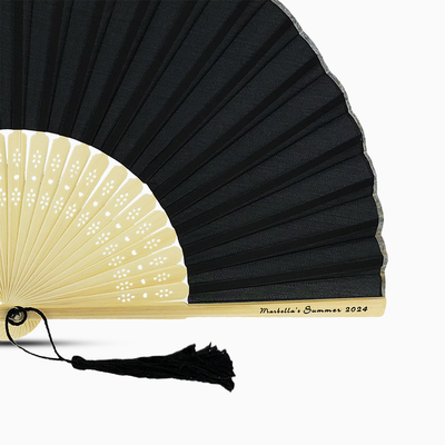 A Black solid color hand fan, featuring a personal message printed  on main rib.