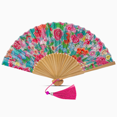 Floral patterned hand fan with a pink tassel on a white background