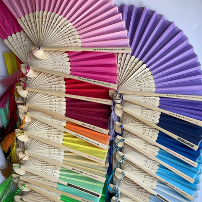 Colorful hand fans arranged in a circular pattern on a white background