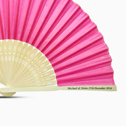 A Dark Pink solid color hand fan, featuring a personal message printed  on main rib.