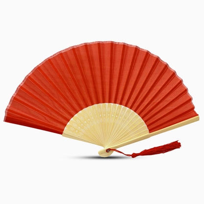 A red fabric fan with a tassel, showcasing a solid color design.