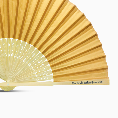 A Dark Gold solid color hand fan, featuring a personal message printed  on main rib.