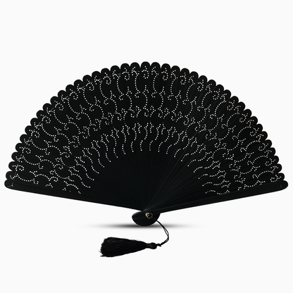 A black wooden hand fan with hollow-out carvings and a tassel on the side, elegantly displayed.