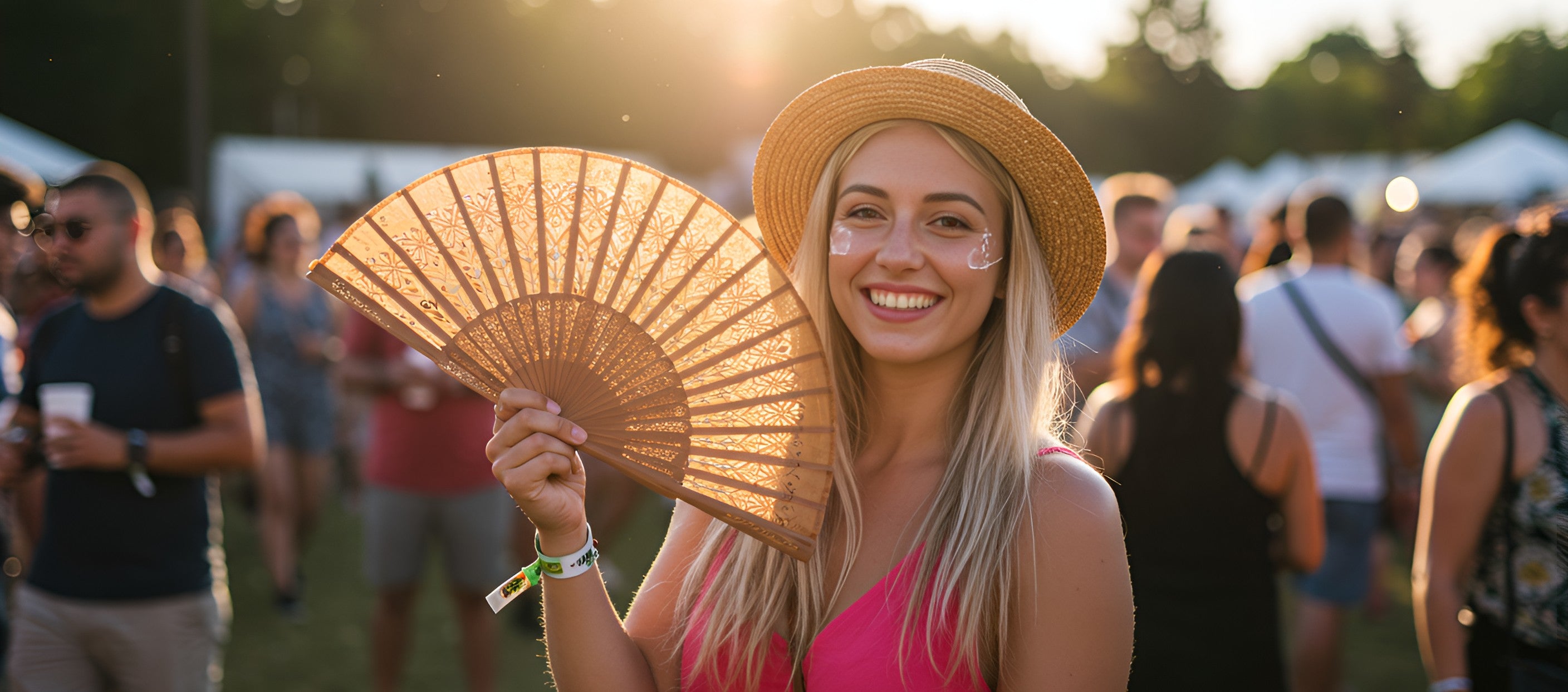  A woman at a music festival holds a wooden fan, enjoying the atmosphere and staying cool in the crowd.
