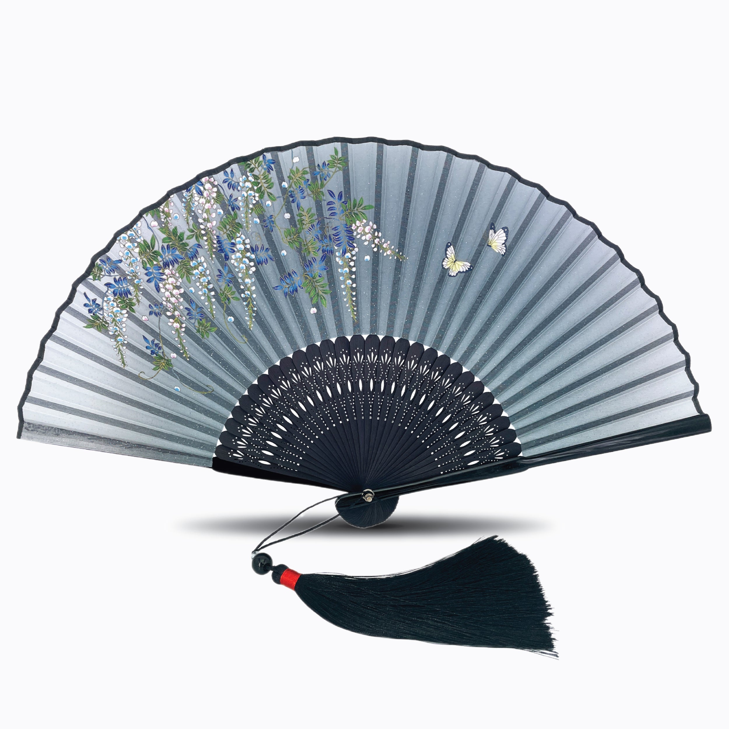 Handheld folding fan featuring delicate floral and butterfly artwork on premium silk fabric, with intricately carved black bamboo ribs and a matching black tassel, displayed against a clean white background