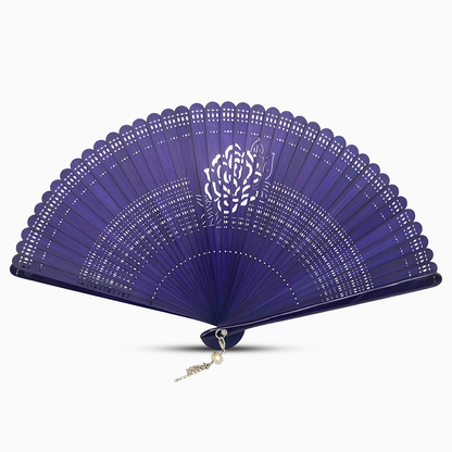 A navy blue wooden hand fan with a rose flower cut design and a decorative tassel attached.