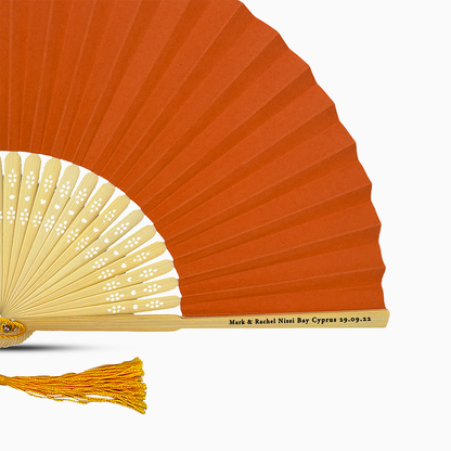 A Orange solid color hand fan, featuring a personal message printed  on main rib.