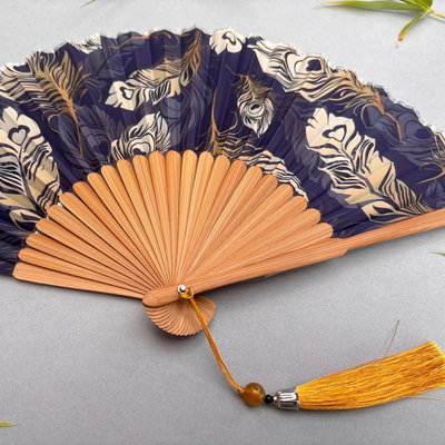 Handheld fan with peacock feather pattern on a gray background