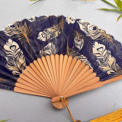 Handheld fan with peacock feather pattern on a gray background