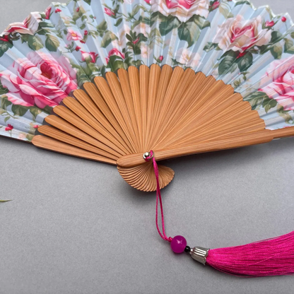 Floral-patterned hand fan with pink roses on a gray background
