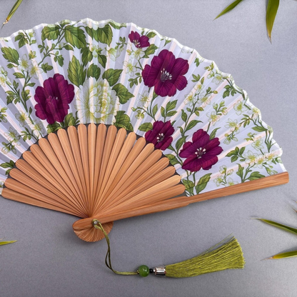 Floral-patterned hand fan on a gray background
