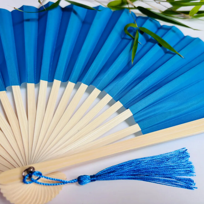 Baby Blue hand fan with a tassel on a white background