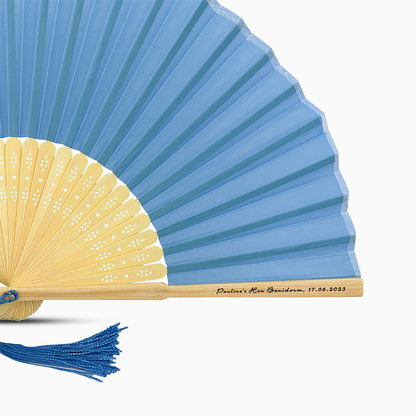 A Blue solid color hand fan, featuring a personal message printed  on main rib.